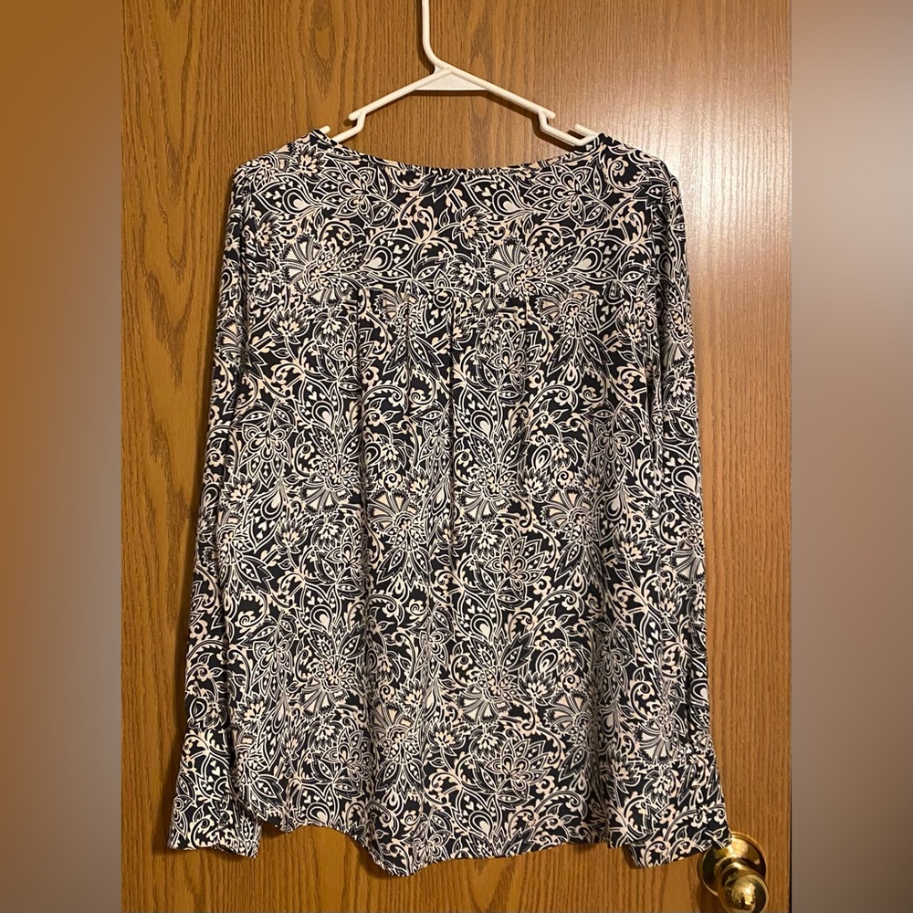 Long sleeve blouse with wide wrist cuff. Button detail at the shoulders